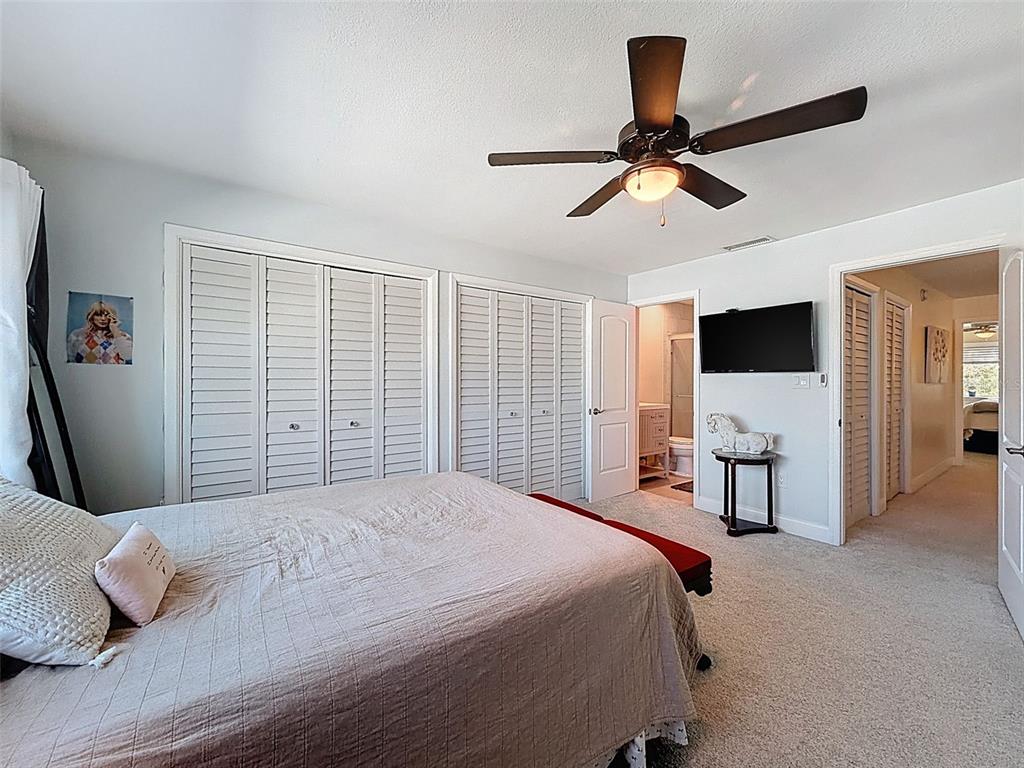 433 Paula Drive South, Unit 23 Dunedin, FL 34698 - Photo 35 of 56 a bedroom with a bed and a flat screen tv