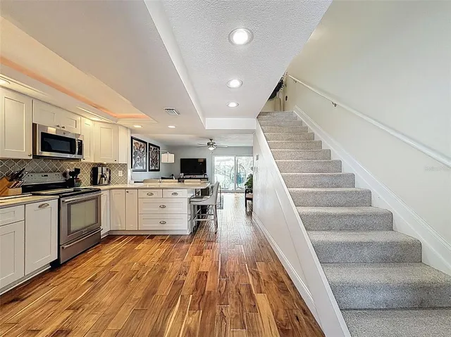 a kitchen with granite countertop white cabinets and white appliances