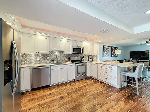 a kitchen with granite countertop a refrigerator stove top oven and sink