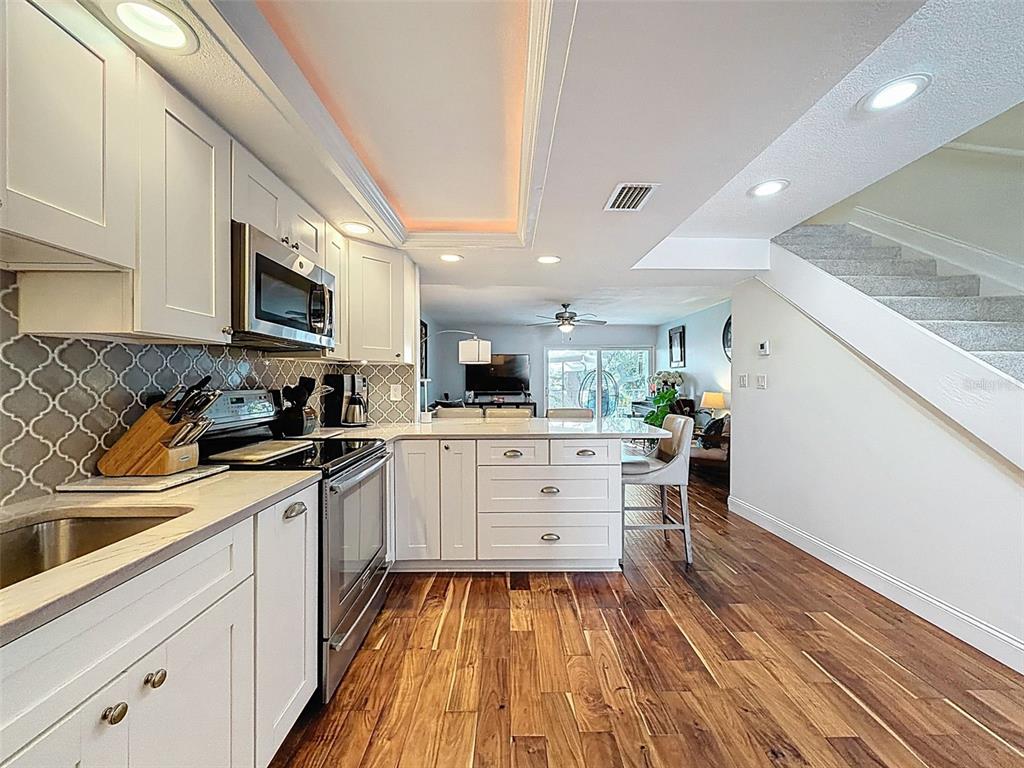 433 Paula Drive South, Unit 23 Dunedin, FL 34698 - Photo 10 of 56 a kitchen with white cabinets and appliances