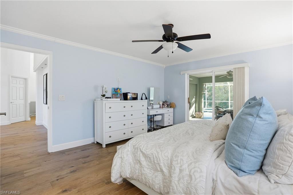 272 Johnnycake Drive Naples, FL 34110 - Photo 13 of 33 a bedroom with a bed and wooden floor