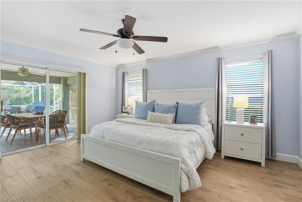 272 Johnnycake Drive Naples, FL 34110 - Photo 14 of 33 a spacious bedroom with a bed a table and large windows