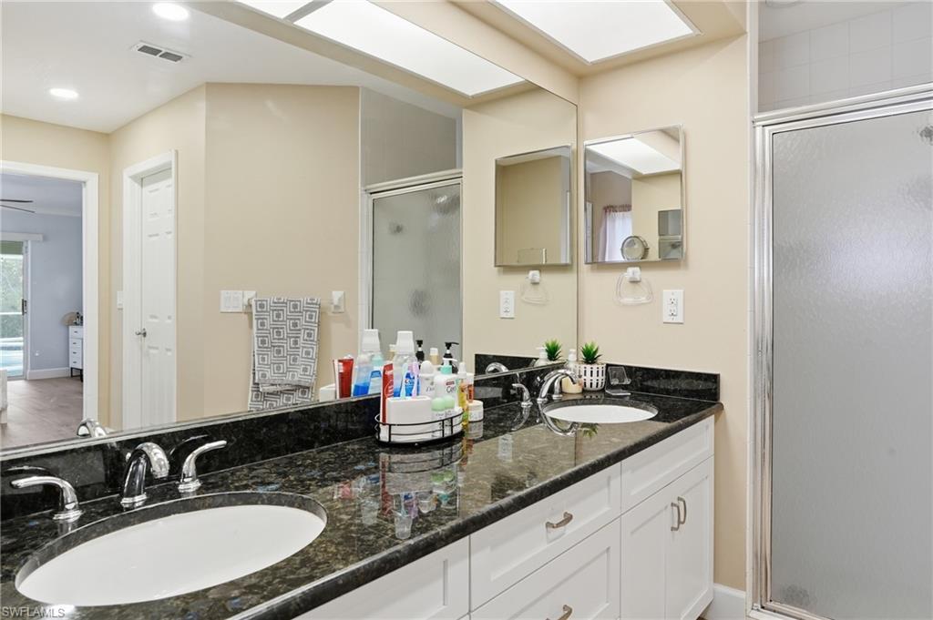 272 Johnnycake Drive Naples, FL 34110 - Photo 15 of 33 a bathroom with double sink and a mirror