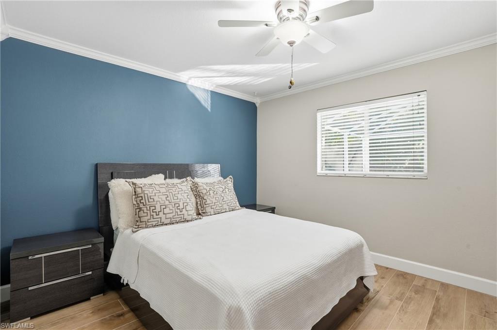 272 Johnnycake Drive Naples, FL 34110 - Photo 17 of 33 a bedroom with a bed and a chandelier