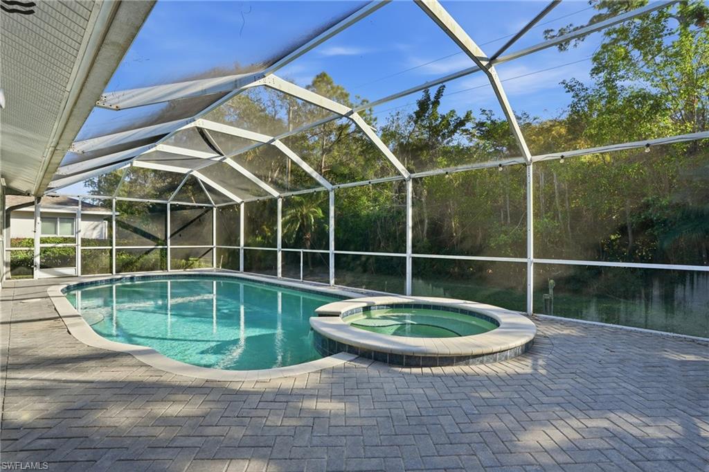 272 Johnnycake Drive Naples, FL 34110 - Photo 23 of 33 a view of a swimming pool with a wooden fence