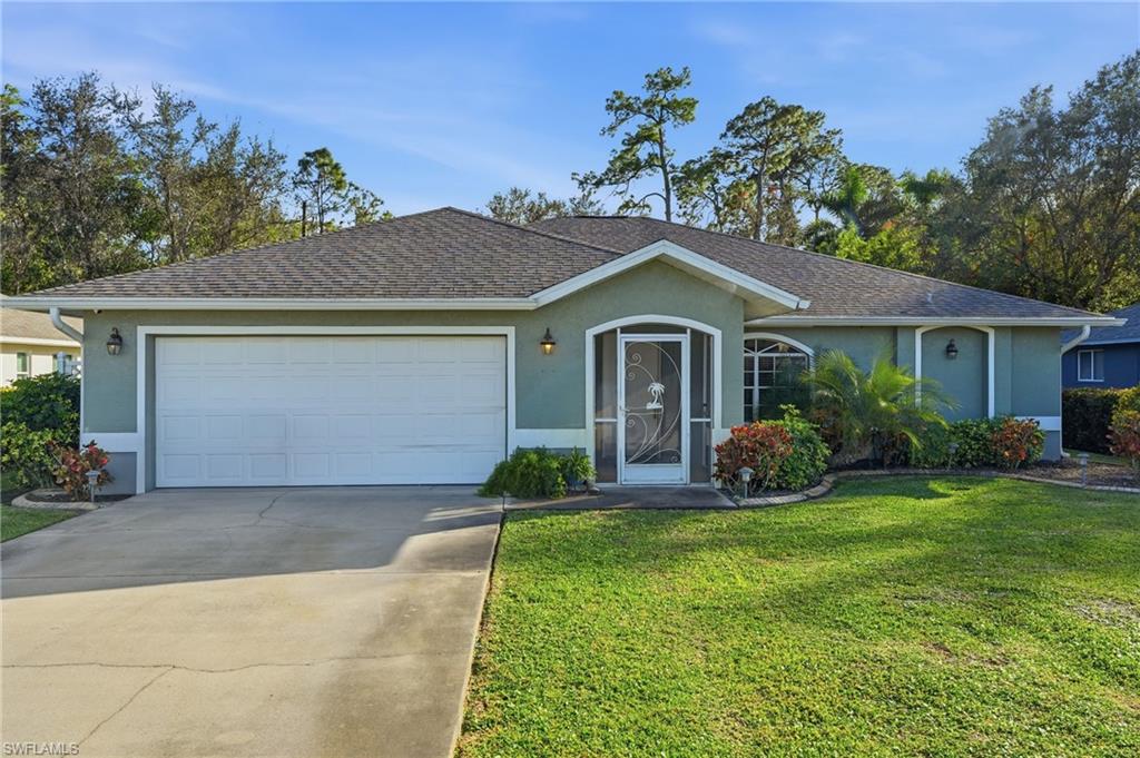 272 Johnnycake Drive Naples, FL 34110 - Photo 29 of 33 a front view of a house with a yard and garage