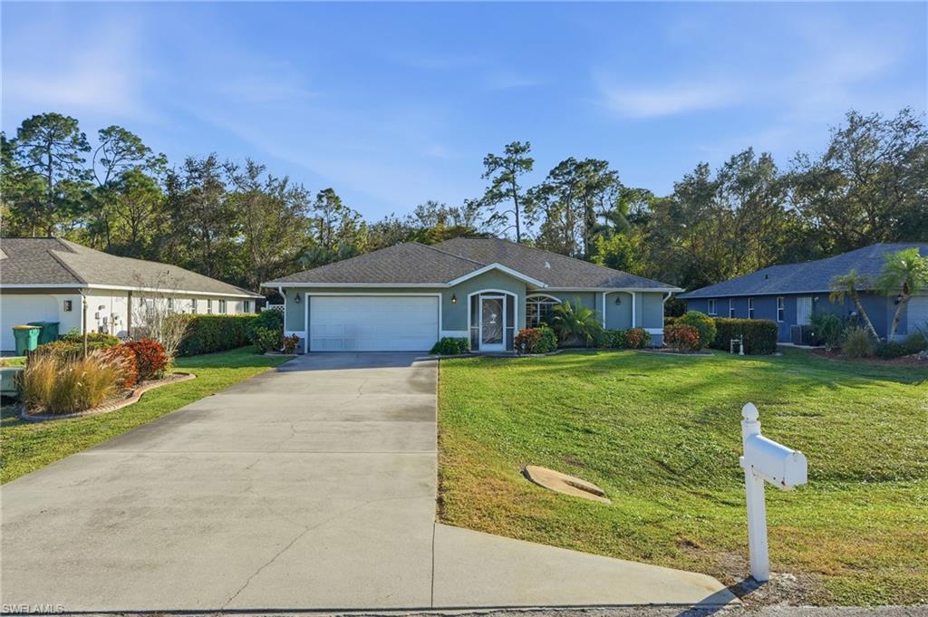 272 Johnnycake Drive Naples, FL 34110 - Photo 31 of 33 a front view of a house with a yard and a garage