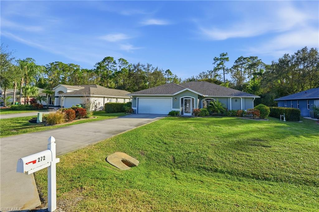 272 Johnnycake Drive Naples, FL 34110 - Photo 32 of 33 a front view of house with yard and trees in the background