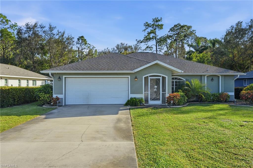 272 Johnnycake Drive Naples, FL 34110 - Photo 33 of 33 a front view of a house with a garden and yard