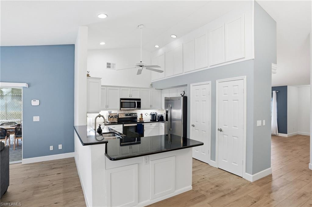 272 Johnnycake Drive Naples, FL 34110 - Photo 5 of 33 a kitchen with stainless steel appliances kitchen island granite countertop a refrigerator and a stove