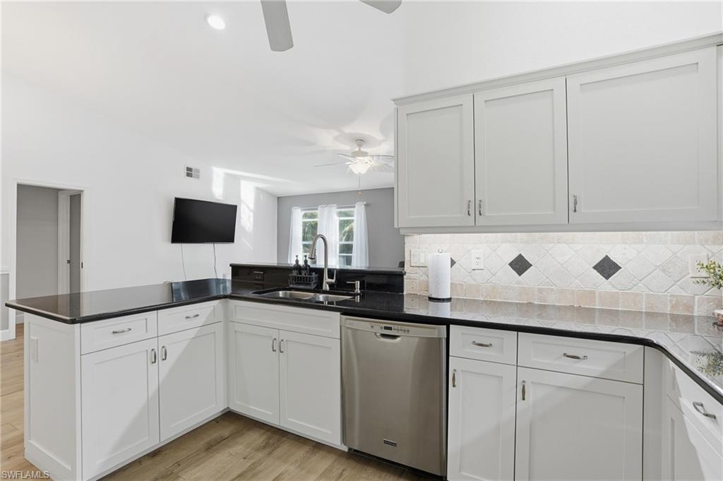 272 Johnnycake Drive Naples, FL 34110 - Photo 7 of 33 a kitchen with granite countertop a sink and white cabinets