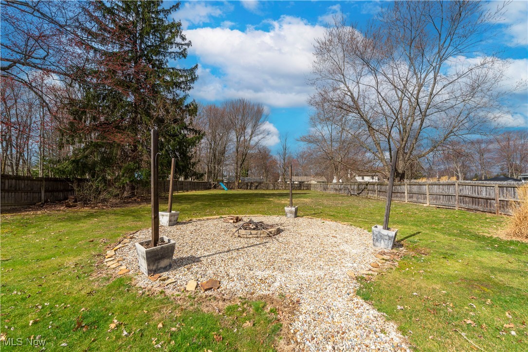 11518 Prospect Road Strongsville, OH 44149 - Photo 38 of 46 View of yard with a fire pit, a fenced backyard, and a playground