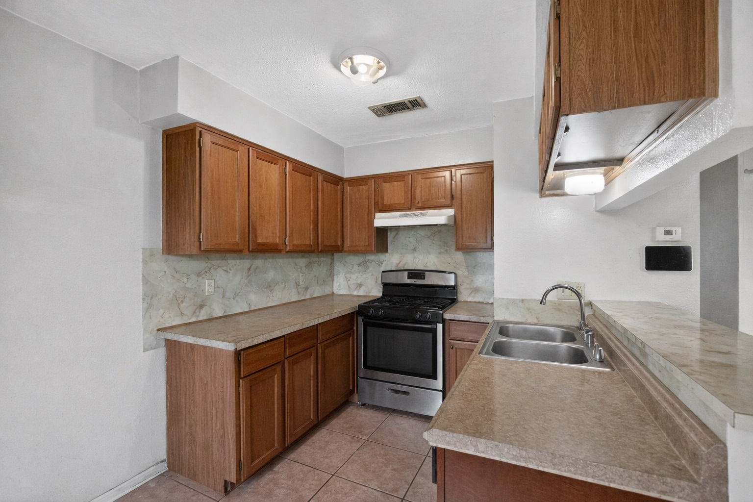 6015 Carnation Terrace Austin, TX 78741 - Photo 12 of 12 a kitchen with stainless steel appliances granite countertop a sink stove and refrigerator