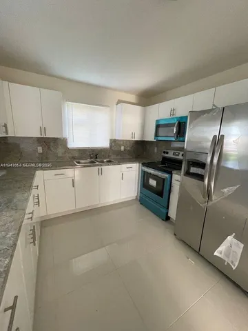 a kitchen with stainless steel appliances granite countertop a refrigerator sink and stove