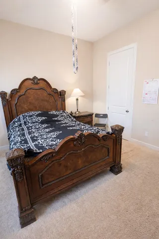 a bedroom with a bed and a lamp on dresser