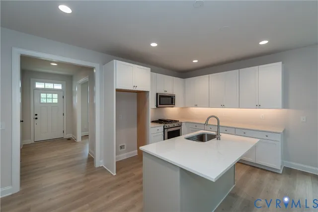 a kitchen with a sink a refrigerator and cabinets