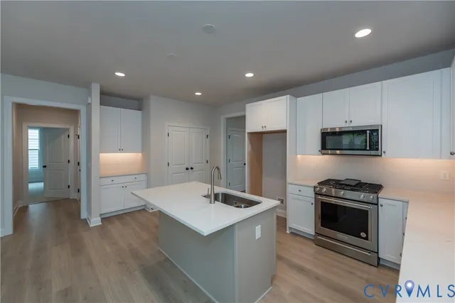 a kitchen with a sink stainless steel appliances and white cabinets