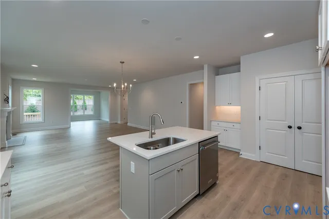 a kitchen that has a sink a window and chairs in it