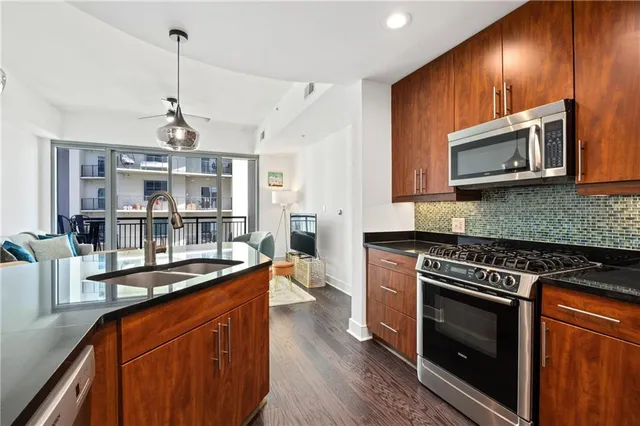 a dining table with wooden floor and kitchen view