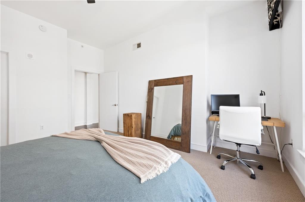 222 12th Street Northeast, Unit 1801 Atlanta, GA 30309 - Photo 19 of 50 a bedroom with a bed and a chair
