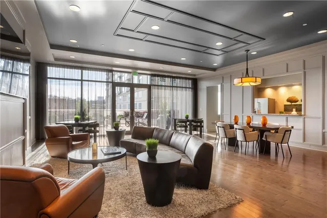 a living room with furniture a large window and wooden floor