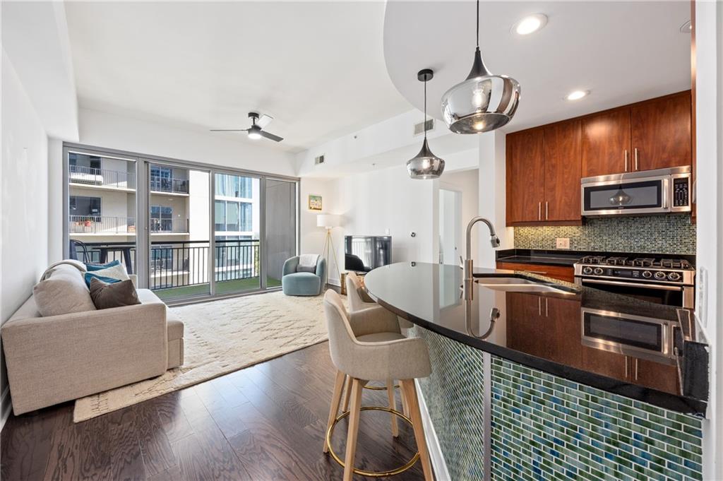 222 12th Street Northeast, Unit 1801 Atlanta, GA 30309 - Photo 4 of 50 a kitchen with stainless steel appliances granite countertop a stove top oven a sink a counter space and cabinets