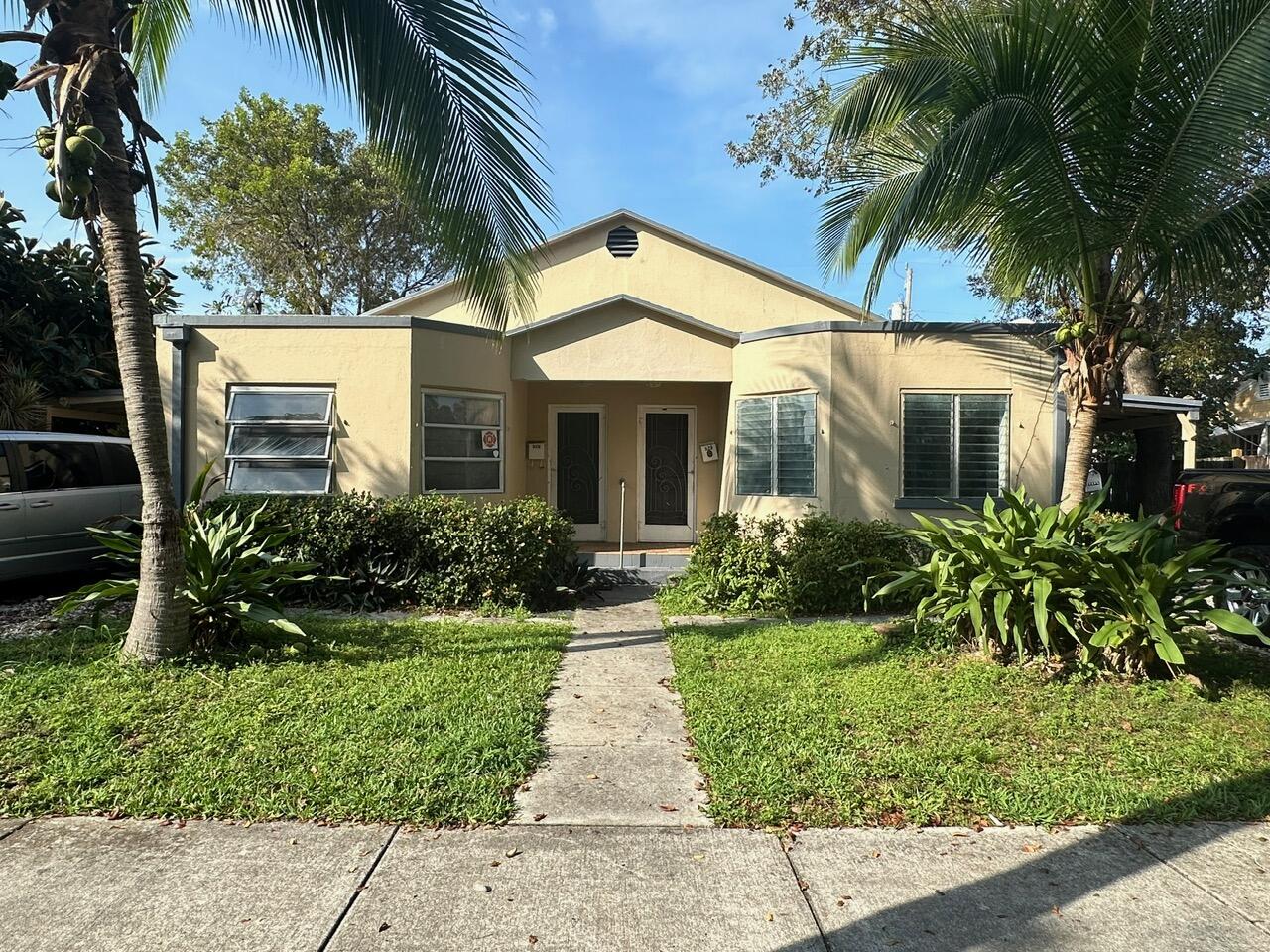 523 48th Street West Palm Beach, FL 33407 - Photo 26 of 33 a front view of a house with a yard and potted plants