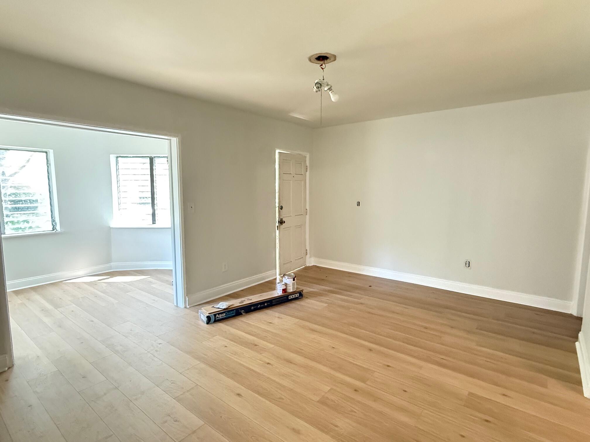 523 48th Street West Palm Beach, FL 33407 - Photo 3 of 33 an empty room with wooden floor and window