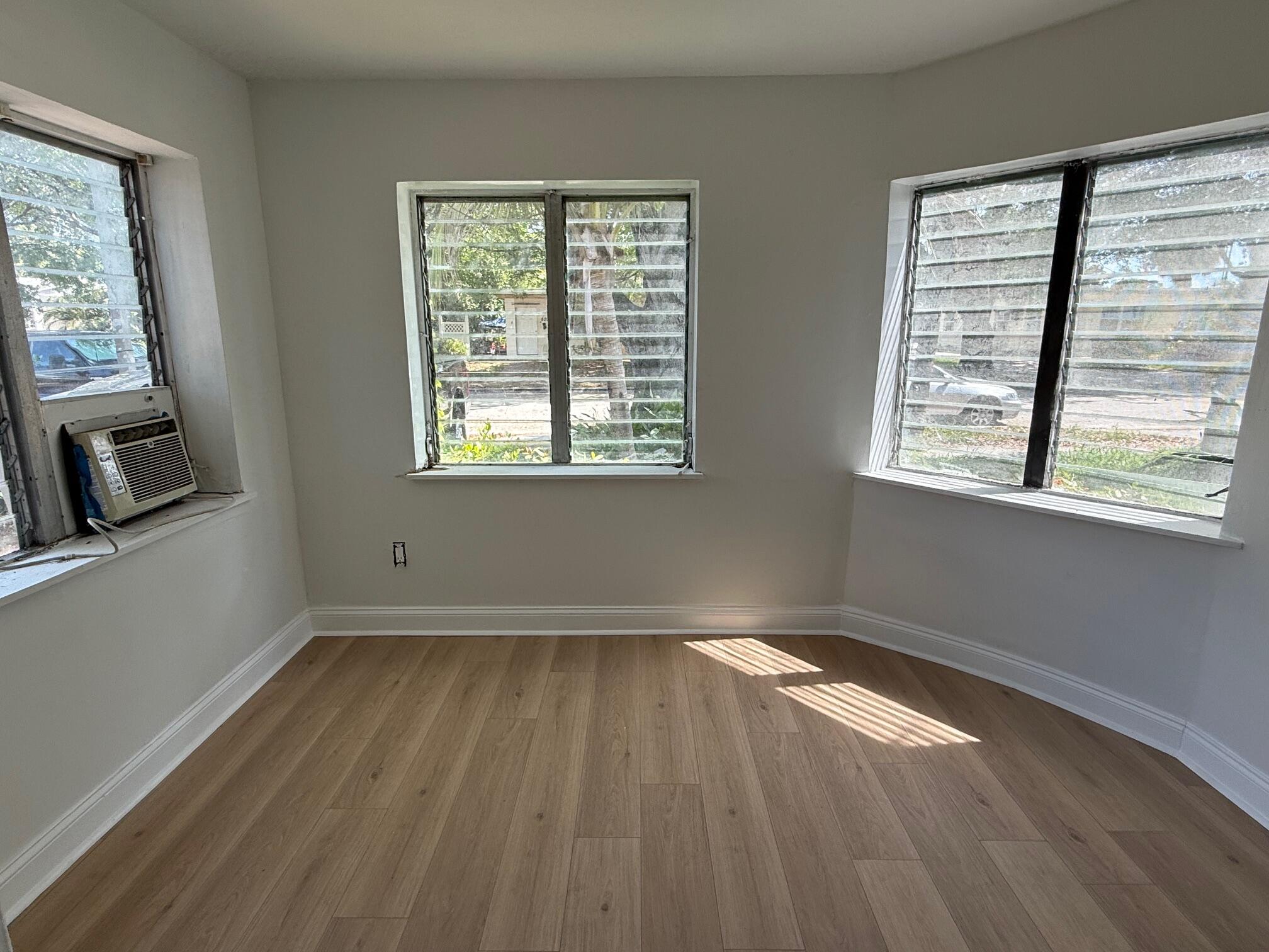 523 48th Street West Palm Beach, FL 33407 - Photo 5 of 33 a view of an empty room with wooden floor and a window
