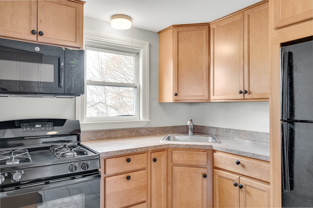 23 Weeks Avenue Boston, MA 02131 - Photo 15 of 34 a kitchen with granite countertop white cabinets stainless steel appliances and a window
