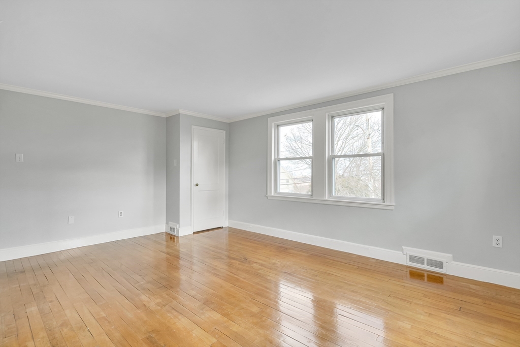 23 Weeks Avenue Boston, MA 02131 - Photo 5 of 34 an empty room with wooden floor and windows