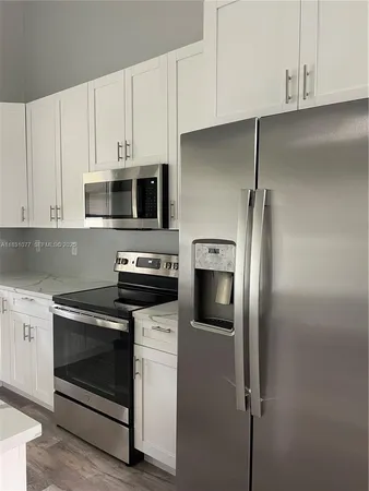 a kitchen with cabinets stainless steel appliances and a counter space