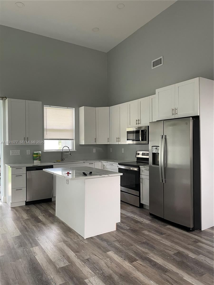 2550 North Arrowhead Road, Unit 2550 Avon Park, FL 33825 - Photo 7 of 9 a kitchen with a refrigerator a sink a stove a microwave and cabinets