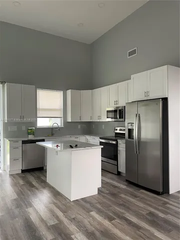 a kitchen with a refrigerator a sink a stove a microwave and cabinets