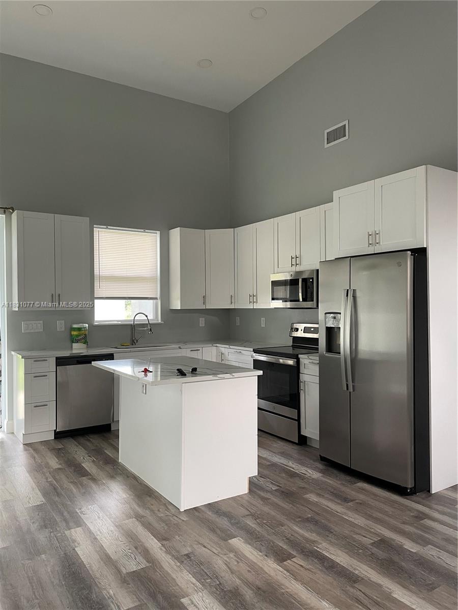 2550 North Arrowhead Road, Unit 2550 Avon Park, FL 33825 - Photo 7 of 9 a kitchen with a refrigerator a sink a stove a microwave and cabinets