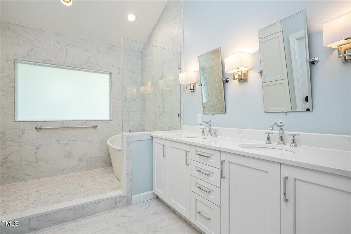 9228 Oneal Road Raleigh, NC 27613 - Photo 12 of 45 a bathroom with a double vanity sink mirror and bathtub