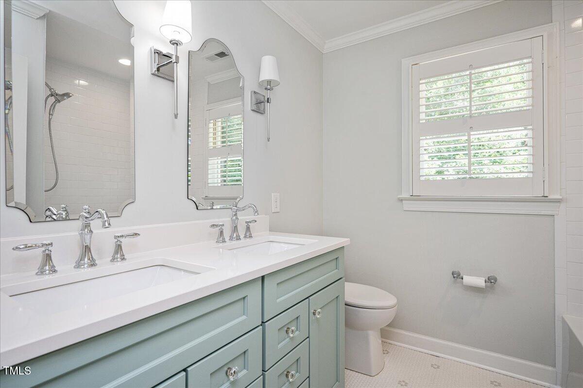 9228 Oneal Road Raleigh, NC 27613 - Photo 30 of 45 a bathroom with a granite countertop sink a toilet and a mirror