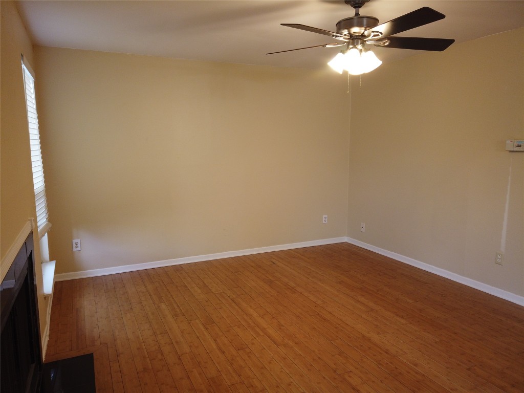 1000 West 26th Street, Unit 110 Austin, TX 78705 - Photo 3 of 12 an empty room with wooden floor fan and windows