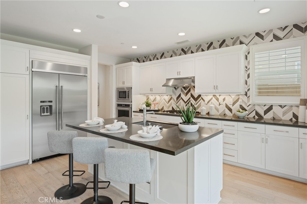 287 Barnes Road Tustin, CA 92782 - Photo 13 of 54 a kitchen with stainless steel appliances kitchen island granite countertop a sink and cabinets