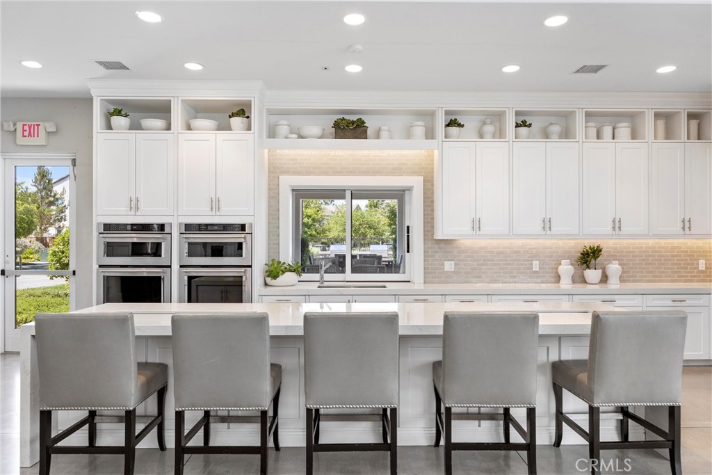 287 Barnes Road Tustin, CA 92782 - Photo 51 of 54 a kitchen with stainless steel appliances granite countertop a stove a sink a microwave a dining table and chairs