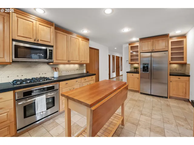 a kitchen with stainless steel appliances granite countertop a stove a sink and a microwave