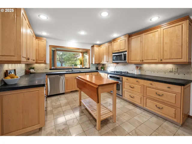 a kitchen with granite countertop a stove sink and cabinets