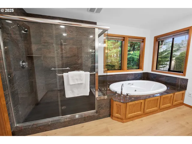 a white bath tub sitting in a bathroom next to a window