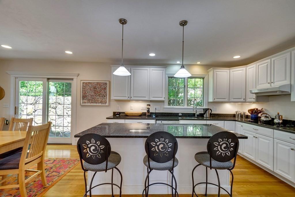 65 Wachusett Road Needham, MA 02492 - Photo 15 of 42 a kitchen with stainless steel appliances granite countertop a stove a refrigerator a kitchen island a table and chairs