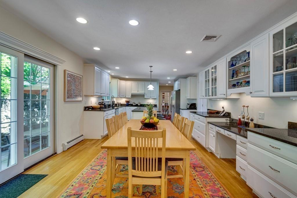 65 Wachusett Road Needham, MA 02492 - Photo 20 of 42 a kitchen with stainless steel appliances granite countertop a stove top oven a sink dishwasher a dining table and chairs with wooden floor