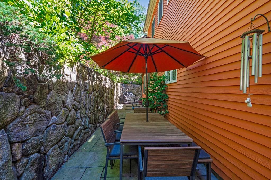 65 Wachusett Road Needham, MA 02492 - Photo 40 of 42 a view of a patio with a table and chairs under an umbrella