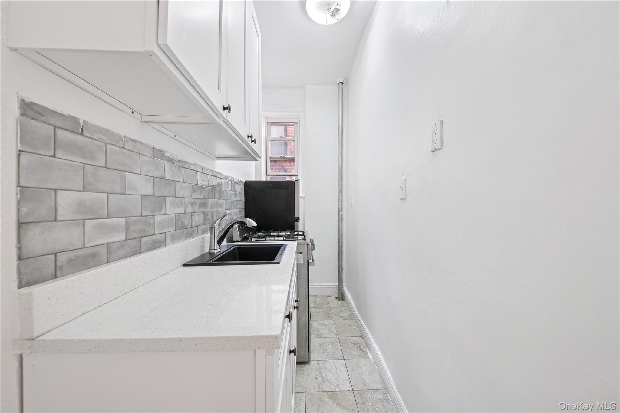 41-25 44th Street, Unit C5 Queens, NY 11104 - Photo 5 of 14 a kitchen with a sink a stove and cabinets