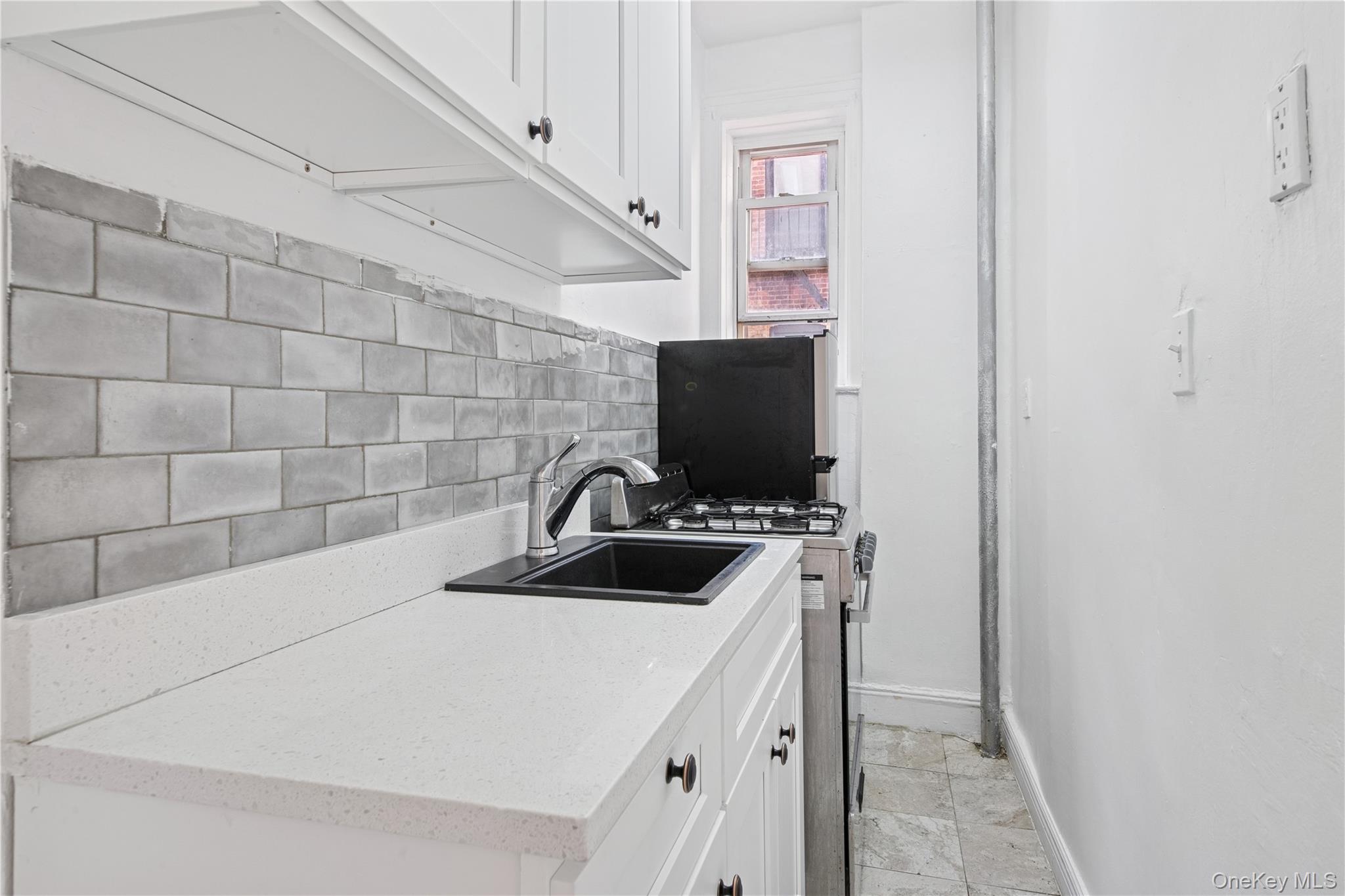 41-25 44th Street, Unit C5 Queens, NY 11104 - Photo 6 of 14 a kitchen with a sink a stove and a refrigerator