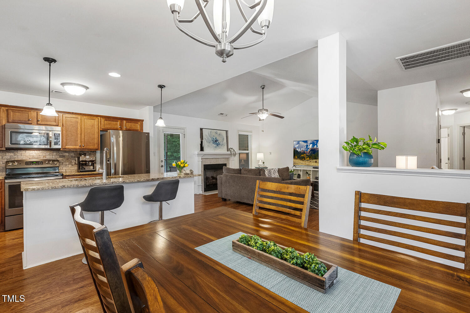 131 Abacos Court Clayton, NC 27520 - Photo 13 of 39 a kitchen with stainless steel appliances kitchen island granite countertop a refrigerator a stove a sink dishwasher and a dining table with wooden floor