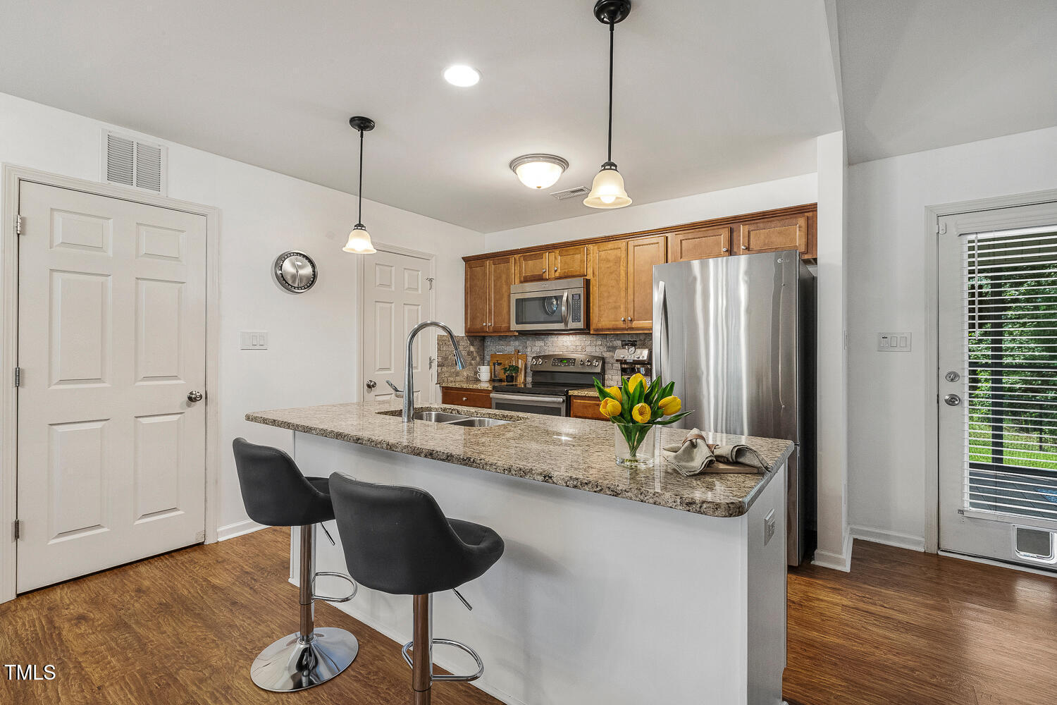 131 Abacos Court Clayton, NC 27520 - Photo 6 of 39 a kitchen with granite countertop a refrigerator a stove a sink and a wooden floor